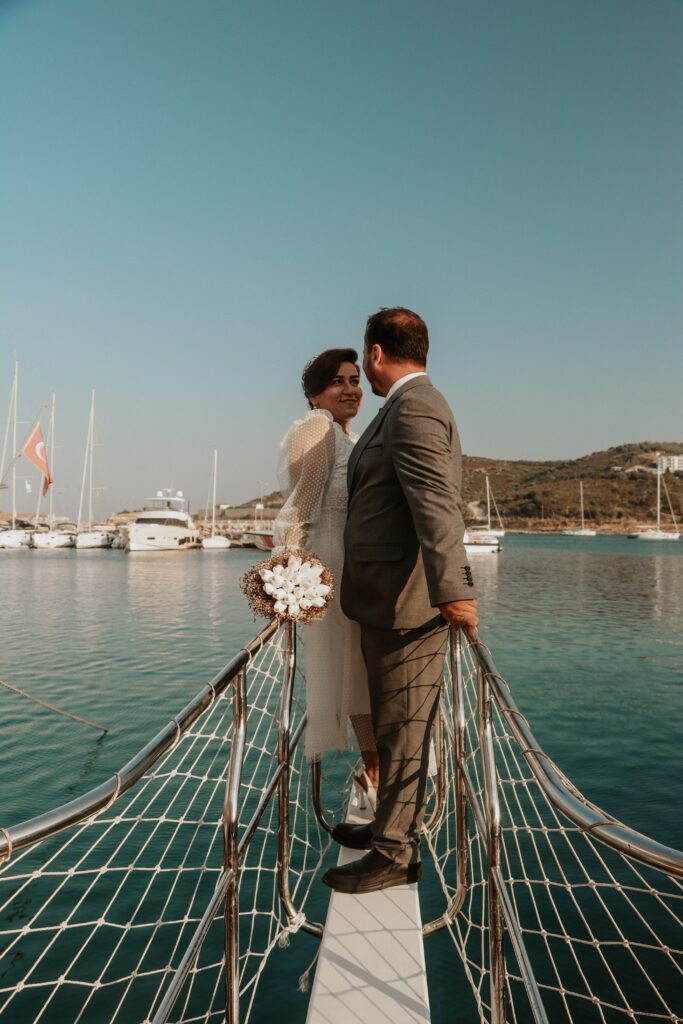 Newly married couple at the bow of a boat